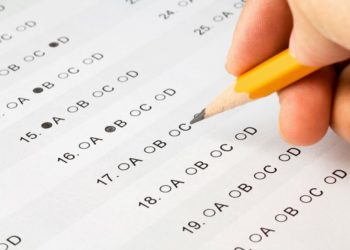 Hand completing a multiple choice exam.